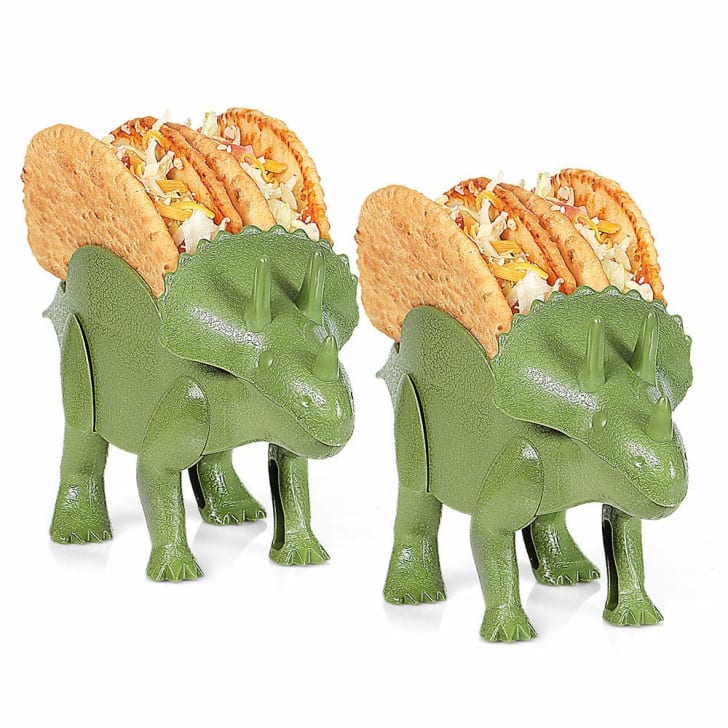 Two dinosaur shaped taco holders with tacos in them.