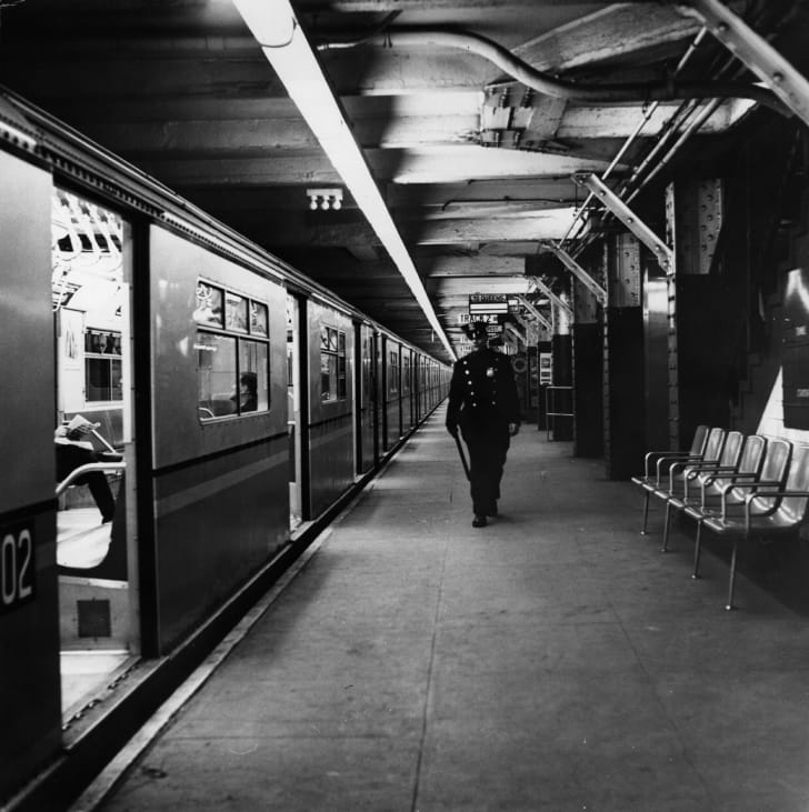 A policeman patrolling an empty New York subway station