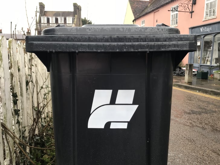 A black trash can features an 'H' logo.