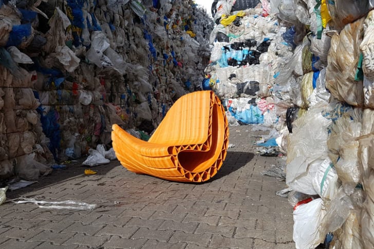 A plastic chair is surrounded by trash