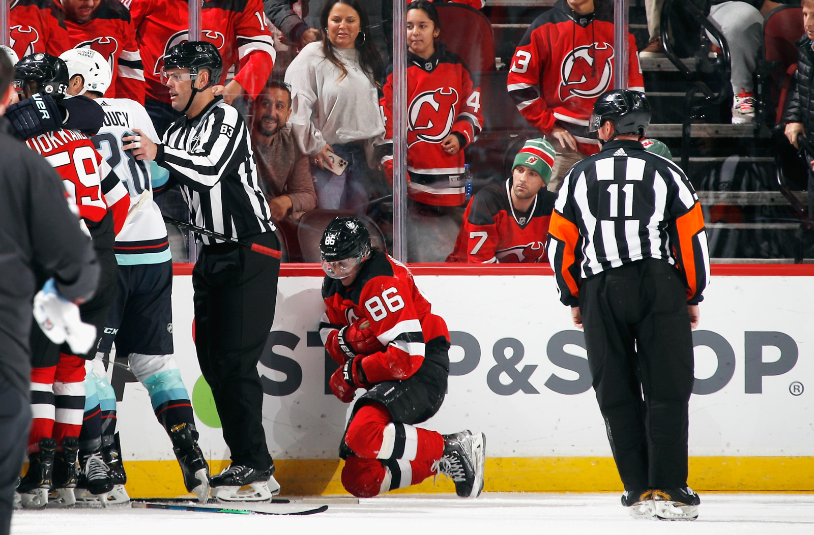 New Jersey Devils' Jack Hughes bleeding on the bench after getting