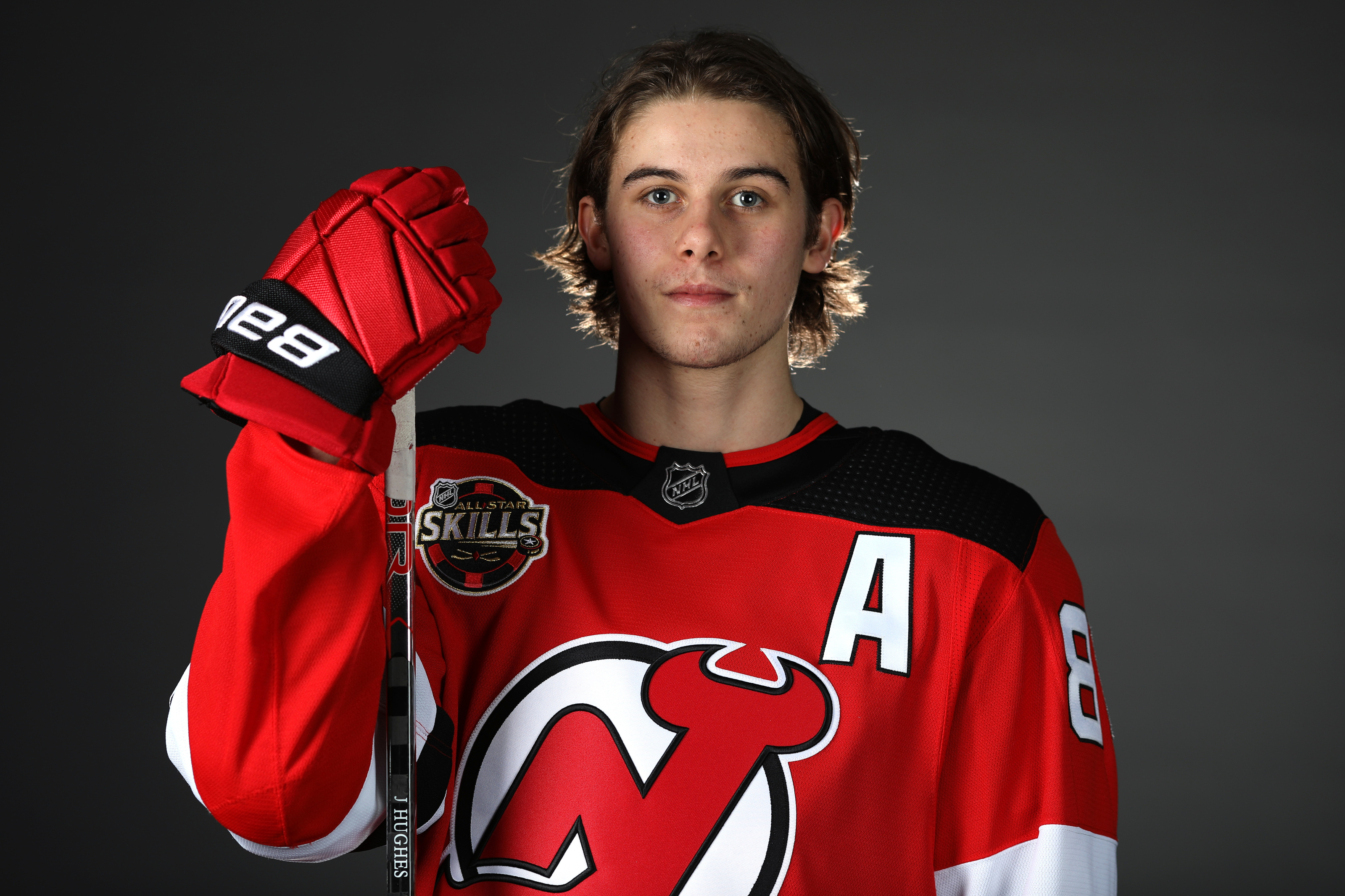 New Jersey Devils players, including Jack Hughes, right, wear