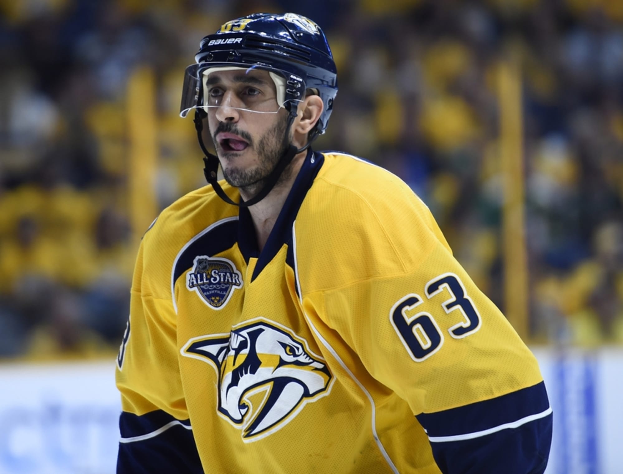Nashville Predators center Mike Ribeiro wears a Military Appreciation jersey  as he tosses a puck into the crowd while warming up before an NHL hockey  game against the Minnesota Wild on Saturday