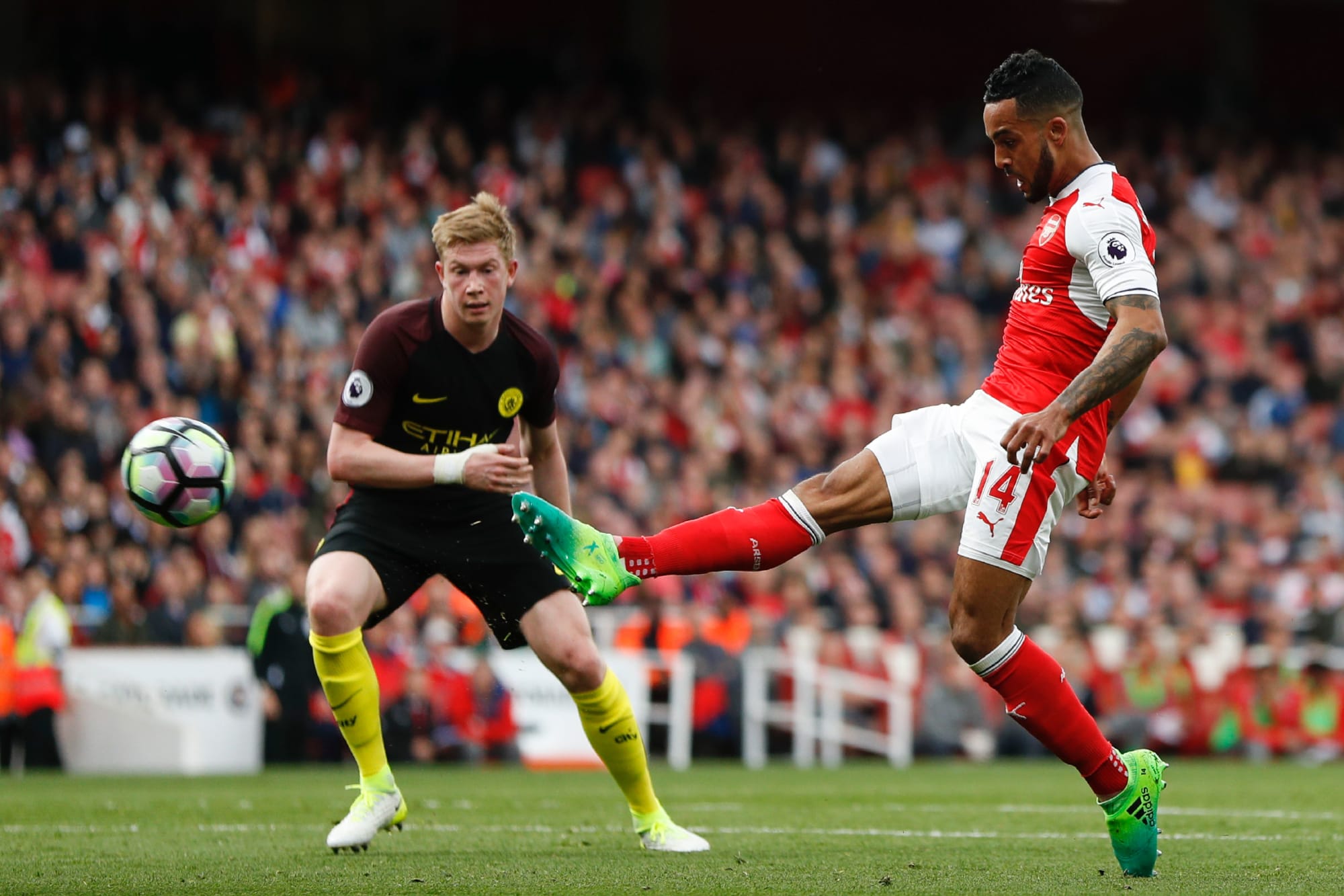  Arsenal's Theo Walcott (right) shoots past Manchester City's Kevin De Bruyne (left) during the Premier League match at Emirates Stadium.
