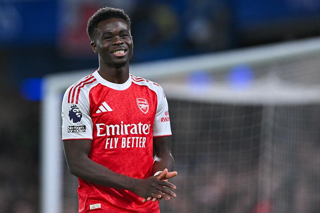Bukayo Saka smiles in Arsenal's red-and-white home shirt