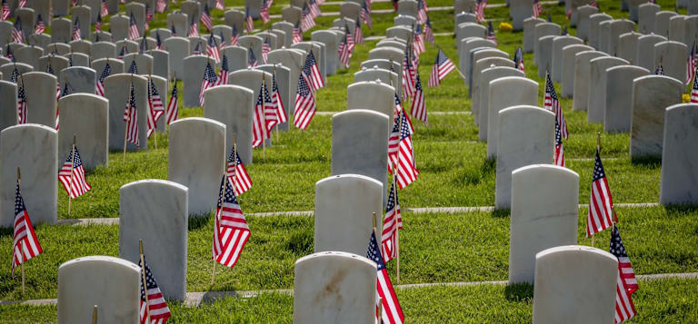 Military grave markers decorated with American flags for Memorial Day.
