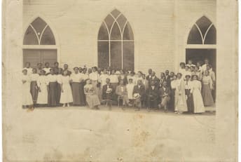 A group of people standing in front of a church—possibly Vernon Chapel AME Church in Tulsa, Oklahoma—in the early 20th century.