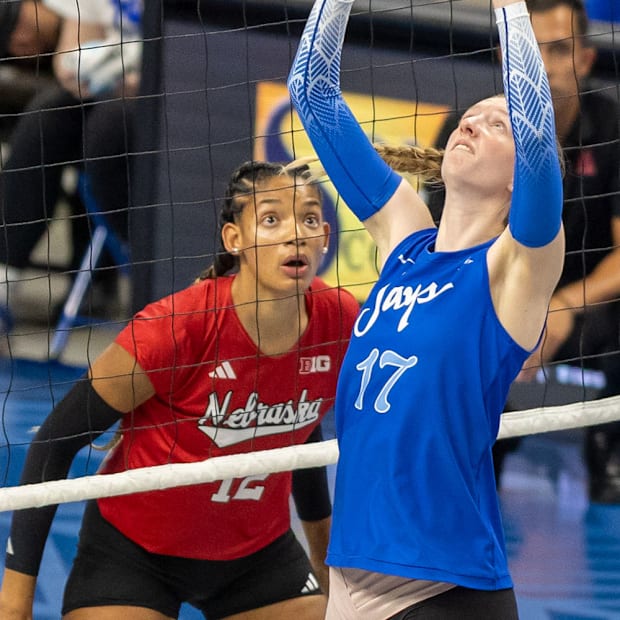 Nebraska outside hitter Taylor Landfair prepares to defend as Creighton setter Annalea Maeder sends a set.