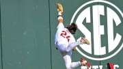Arkansas Razorbacks center fielder Peyton Holt makes a leaping grab of a ball to deep center by Mississippi State's Logan Pulliam on Friday night at Baum-Walker Stadium in Fayetteville, Ark.