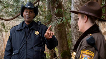 RESIDENT ALIEN -- "Daddy Issues" Episode 407 -- Pictured: (l-r) Corey Reynolds as Sheriff Mike Thompson, Elizabeth Bowen as Deputy Liv Baker -- (Photo by: James Dittiger/USA Network)