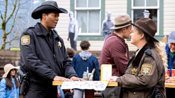 RESIDENT ALIEN -- "Mine Town" Episode 408 -- Pictured: (l-r) Corey Reynolds as Sheriff Mike Thompson, Elizabeth Bowen as Deputy Liv Baker -- (Photo by: James Dittiger/USA Network)