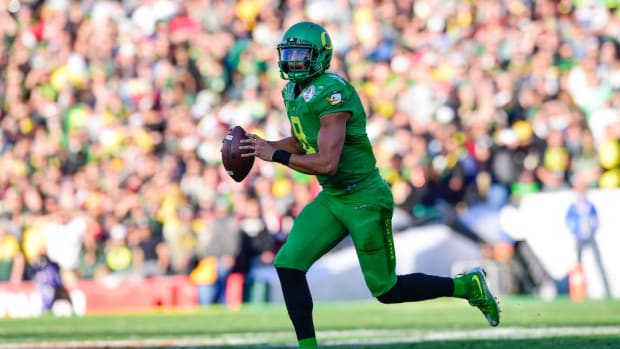 Oregon Ducks quarterback Marcus Mariota (8) rolls out as she looks for a receiver during the second quarter 