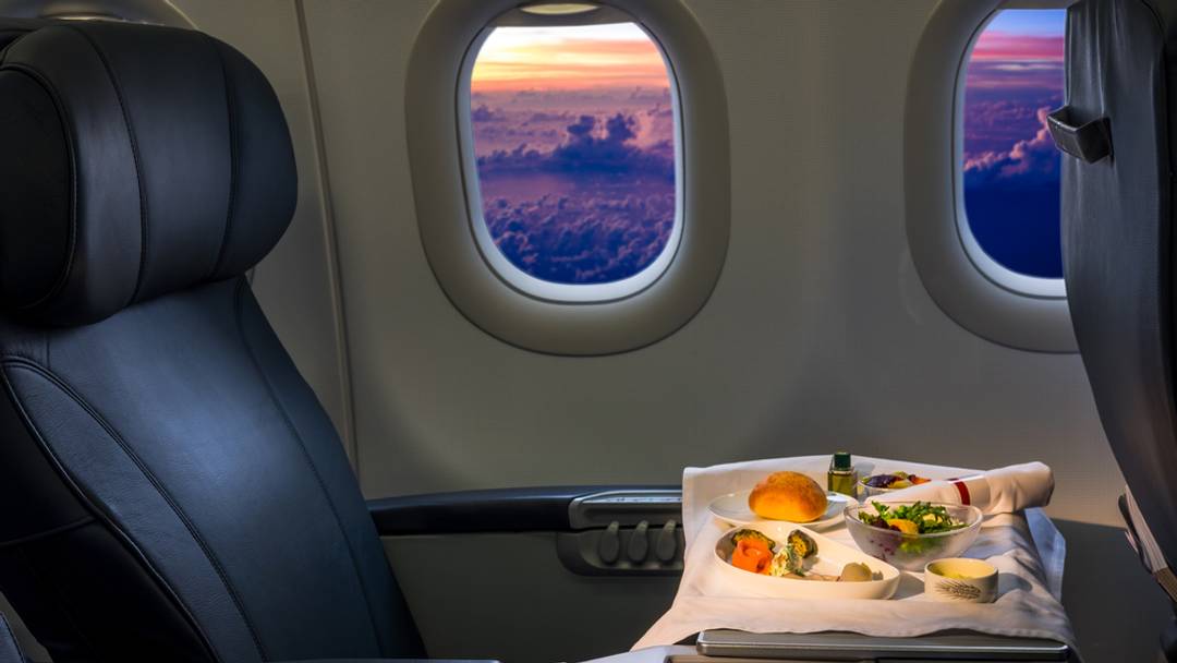 Food in a business class seat with sunset on the side