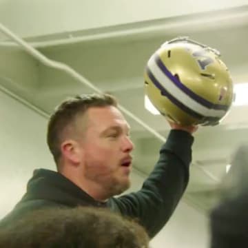 Oregon Ducks coach Dan Lanning holds a Washington helmet at halftime. 