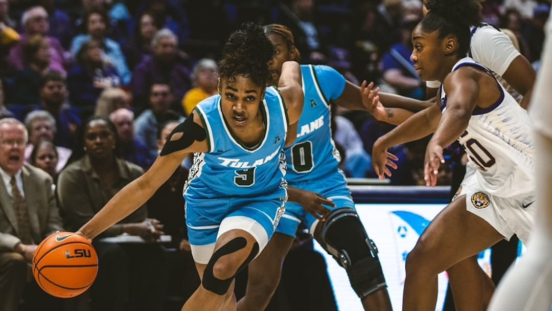 Tulane women's basketball player Kendall Sneed dribble by defender.