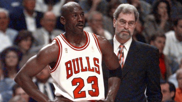 Michael Jordan stands in front of Bulls coach Phil Jackson during a game in 1997.