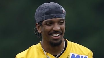 Washington Commanders quarterback Jayden Daniels smiles on the field.