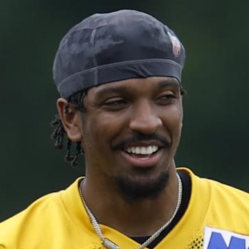 Washington Commanders quarterback Jayden Daniels smiles on the field.