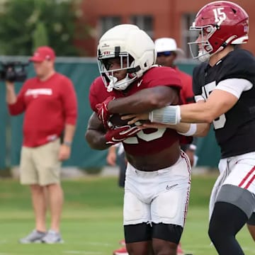 Jam Miller (26) takes a handoff from Ty Simpson (15).