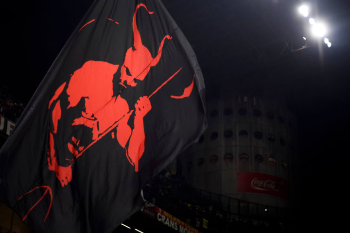 A flag with a devil on it is waved by a fan of AC Milan...
