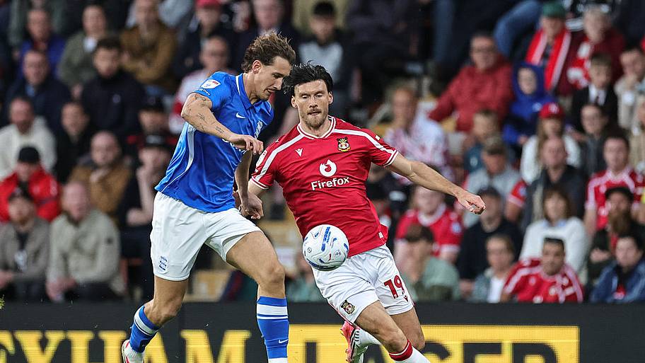 Phil Neumann of Birmingham City and Kieffer Moore of Wrexham compete for the ball.