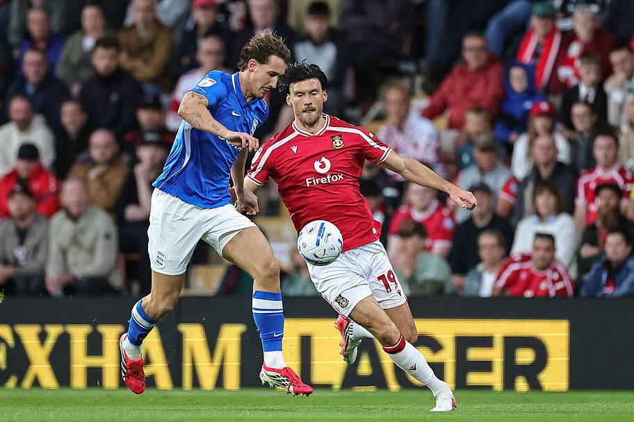 Phil Neumann of Birmingham City and Kieffer Moore of Wrexham compete for the ball.
