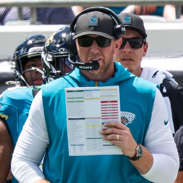 Liam Coen holding a play sheet.