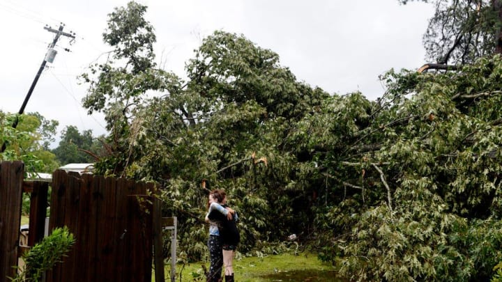 Destanie Elliott gives Savannah Cummings a hug when they see the fallen tree from Hurricane Beryl at her home near Bellevue Road in Haughton on Monday, July 8, 2024.