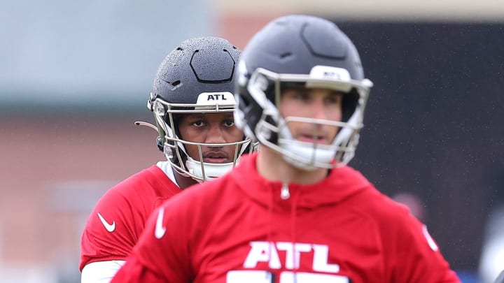 FLOWERY BRANCH, GEORGIA - MAY 14: Quarterback Michael Penix Jr. #9 of the Atlanta Falcons looks on behind quarterback Kirk Cousins #18 during OTA offseason workouts at the Atlanta Falcons training facility on May 14, 2024 in Flowery Branch, Georgia.