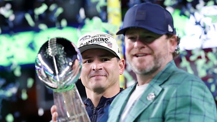 John Schneider, gerente general de los Seattle Seahawks, sostiene el trofeo Lombardi ante la mirada del coach Mike McDonald.