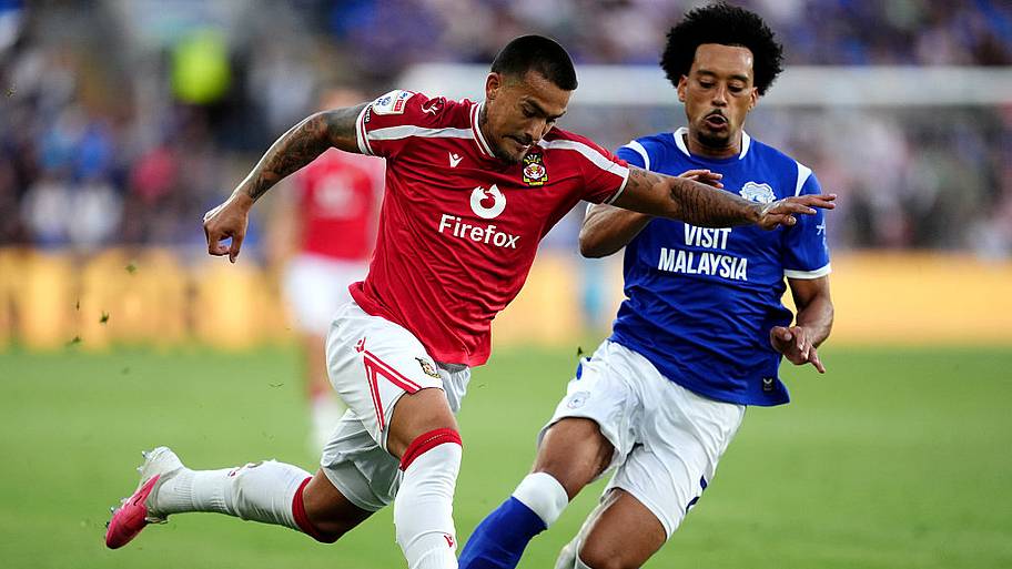 Wrexham's Danny Imray (left) and Cardiff City's Calum Scanlon (R) battle for the ball.