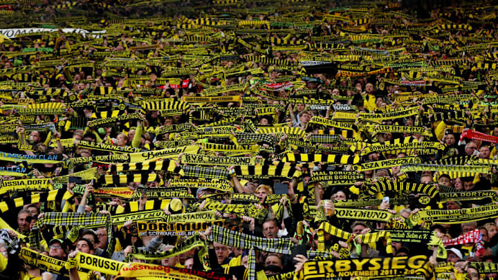 Torcida do Borussia Dortmund na Muralha Amarela com faixas aurinegras.