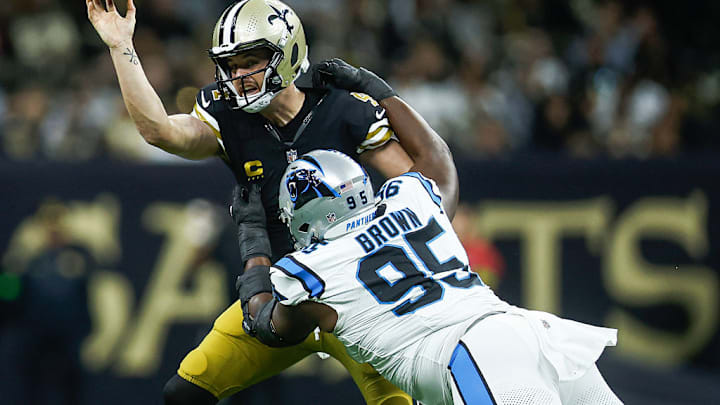 NEW ORLEANS, LOUISIANA - DECEMBER 10: Derek Carr #4 of the New Orleans Saints is tackled by Derrick Brown #95 of the Carolina Panthers during the first quarter at Caesars Superdome on December 10, 2023 in New Orleans, Louisiana.