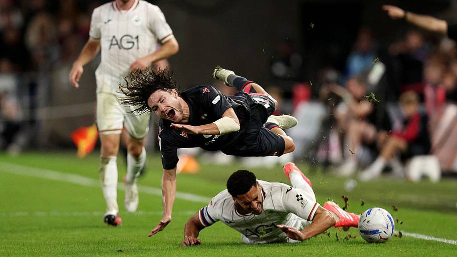 Callum O'Hare of Wrexham is tackled by Ben Cabango of Swansea City.
