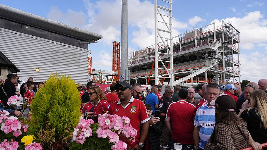 Wrexham fans outside The Turf pub in view of the new stand under construction.
