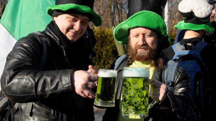 Participants wearing colourful green hats seen holding green beer