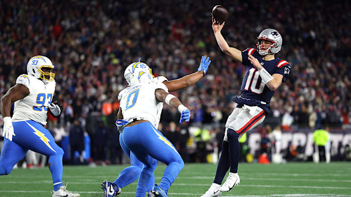 Drake Maye (Patriots) lanza un balón ante la presión de los defensivos de los Chargers