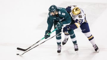 Michigan State defenseman Artyom Levshunov (5) and Notre Dame forward Trevor Janicke (27) battle for the puck during the Michigan State-Notre Dame NCAA hockey game on Friday, February 02, 2024, at Compton Family Ice Arena in South Bend, Indiana.