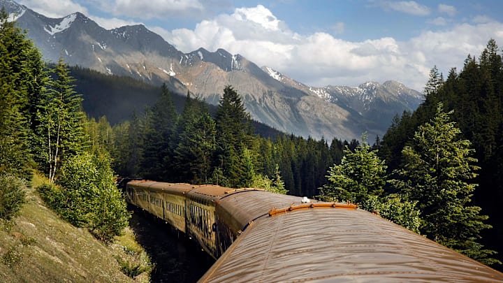 The Rocky Mountaineer crosses Continental Divide in custom coaches through Canadian Rockies.