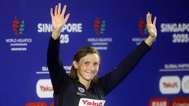 Katie Ledecky waves her hands and smiles while awaiting her gold medal for the 800-meter freestyle.