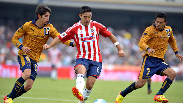 Marco Fabian (C) of Guadalajara vies for