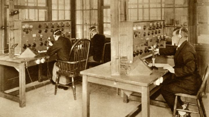 a 1928 sepia photo of three men operating radio machinery