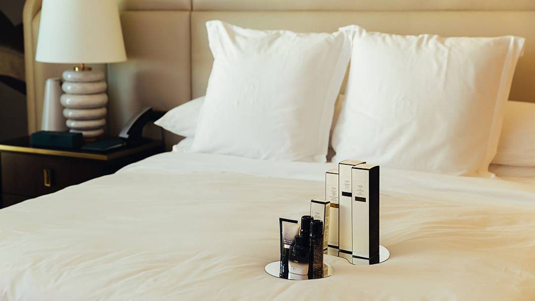 Perfumes sitting on hotel bed