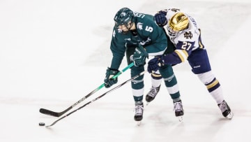 Michigan State defenseman Artyom Levshunov (5) and Notre Dame forward Trevor Janicke (27) battle for the puck during the Michigan State-Notre Dame NCAA hockey game on Friday, February 02, 2024, at Compton Family Ice Arena in South Bend, Indiana.