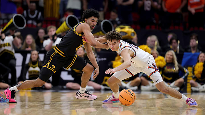 Keaton Wagler, de Illinois Fighting Illini, y Kael Combs, de Iowa Hawkeye, disfrutan el balón.