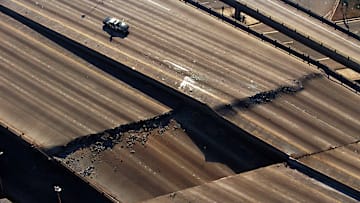 A police car guards a section of a Los Angeles freeway cracked by the magnitude 6.7 Northridge earthquake in 1994.