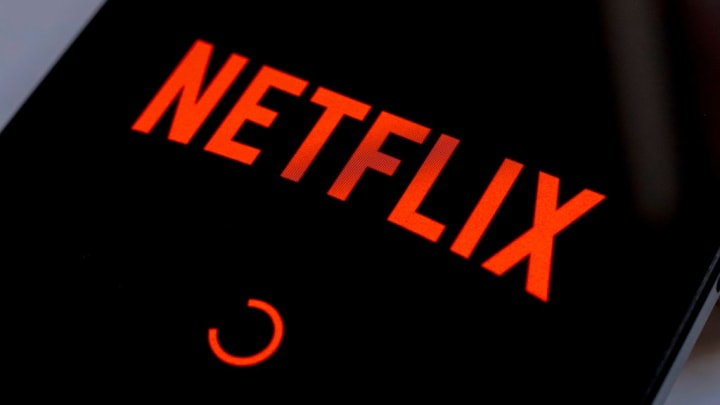 In this photo illustration, the Netflix streaming app logo...