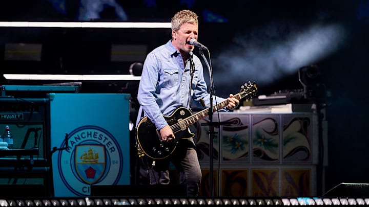 Noel Gallagher, guitarrista y compositor de Oasis, con el esucdo del Manchester City de fondo. Noel Gallagher, guitarrista y compositor de Oasis, con el esucdo del Manchester City de fondo.