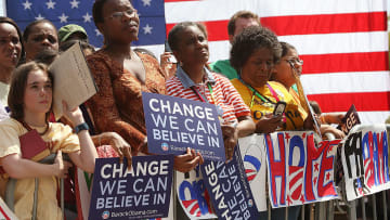 Barack Obama supporters hold posters with his campaign slogan in 2008.