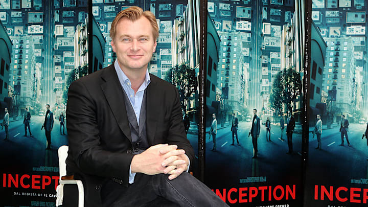 Christopher Nolan in front of 'Inception' posters